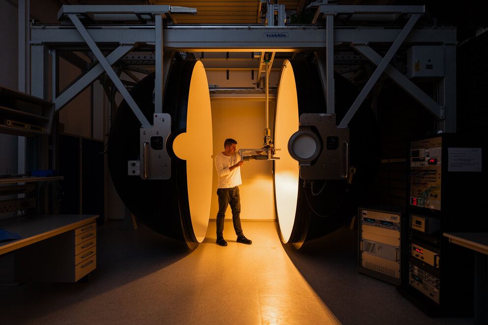 Ulbrichtkugel im SITECO Labor Person, die mithilfe einer Ulbrichtkugel den Lichtstrom einer Straßenleuchte misst.